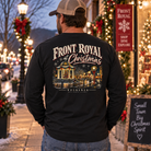 Man wearing Front Royal at Christmas black long sleeve shirt on a festive downtown street decorated with Christmas lights and wreaths