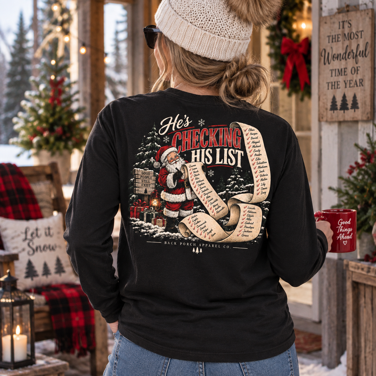 Woman wearing a Back Porch Apparal Santa checking his list long sleeve black shirt