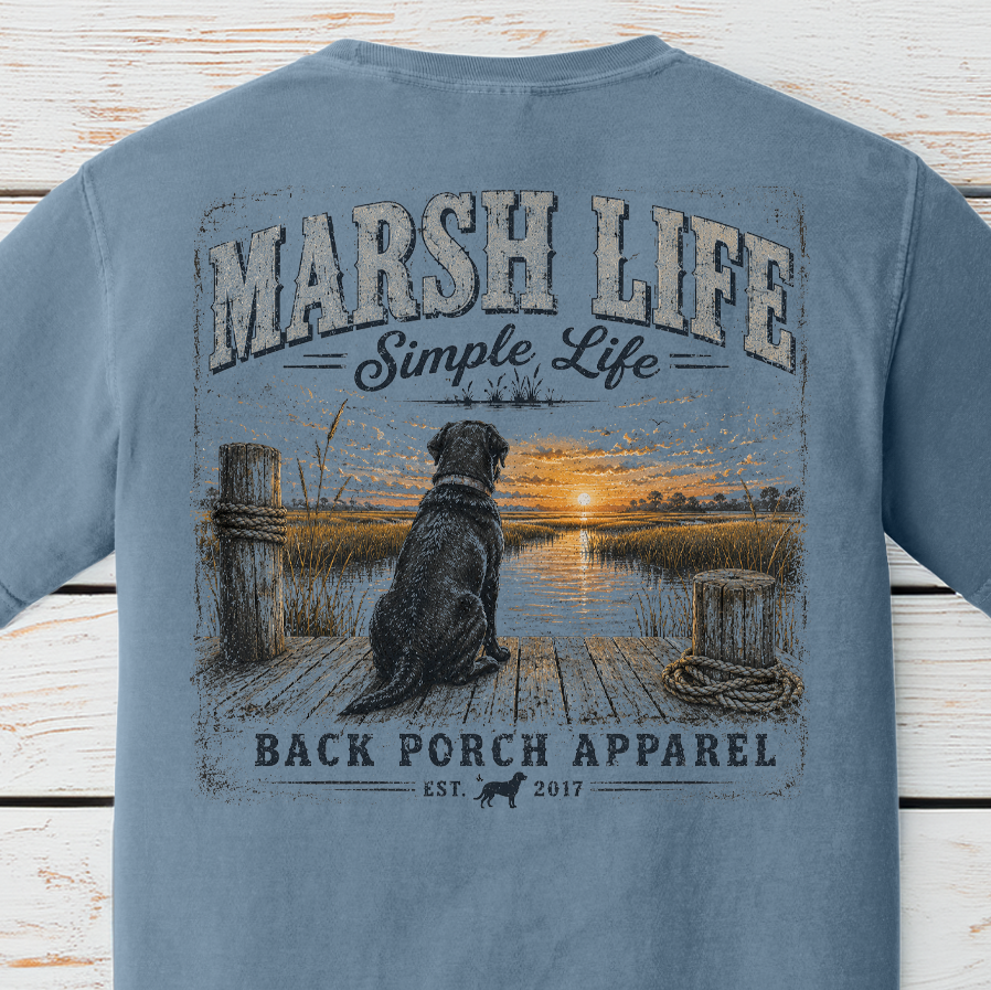 Marsh Life Simple Life graphic t-shirt on Comfort Colors garment-dyed tee featuring a black Labrador sitting on a dock overlooking a coastal marsh at sunset