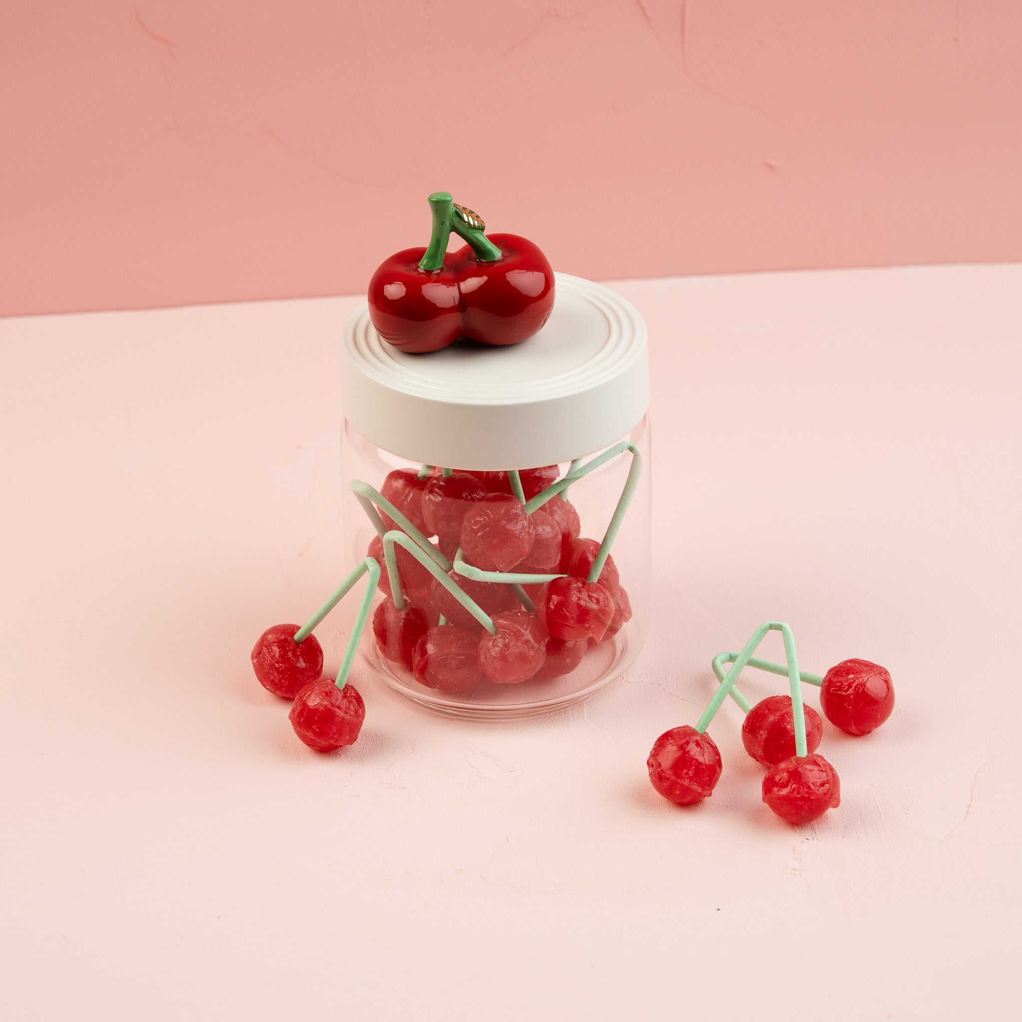 Nora Fleming Super Canister 6-inch filled with cherries and topped with the Cheery Cherries mini, perfect for decorative kitchen storage