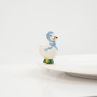 Nora Fleming Porch Pal goose mini wearing blue bonnet on Nora Fleming platter