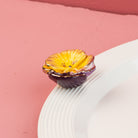 Front view of the Nora Fleming Pansy Pop Mini showcasing detailed yellow and purple pansy petals