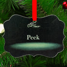 White wolf wildlife art metal ornament titled “Peek,” featuring a wolf peering over water with intense eyes and red hanging ribbon