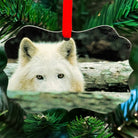 White wolf wildlife art metal ornament titled “Peek,” featuring a wolf peering over water with intense eyes and red hanging ribbon