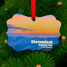 Shenandoah National Park sunset metal ornament with red ribbon, featuring colorful mountain sunset on front and park map with coordinates on back